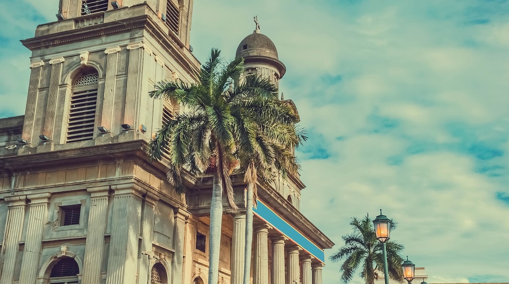 Old cathedral of managua with blue sky, close up of an old cathedral next to lanterns around
