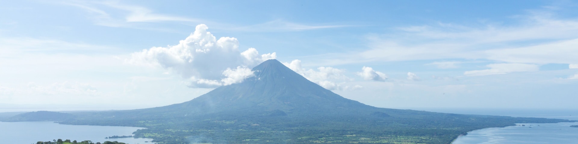 A mountain with a lake in the foreground and a clear sky.