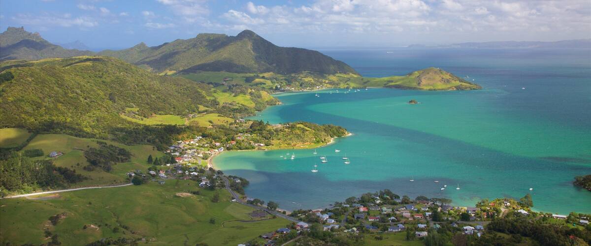 Mount Manaia showing a coastal town, a bay or harbour and mountains