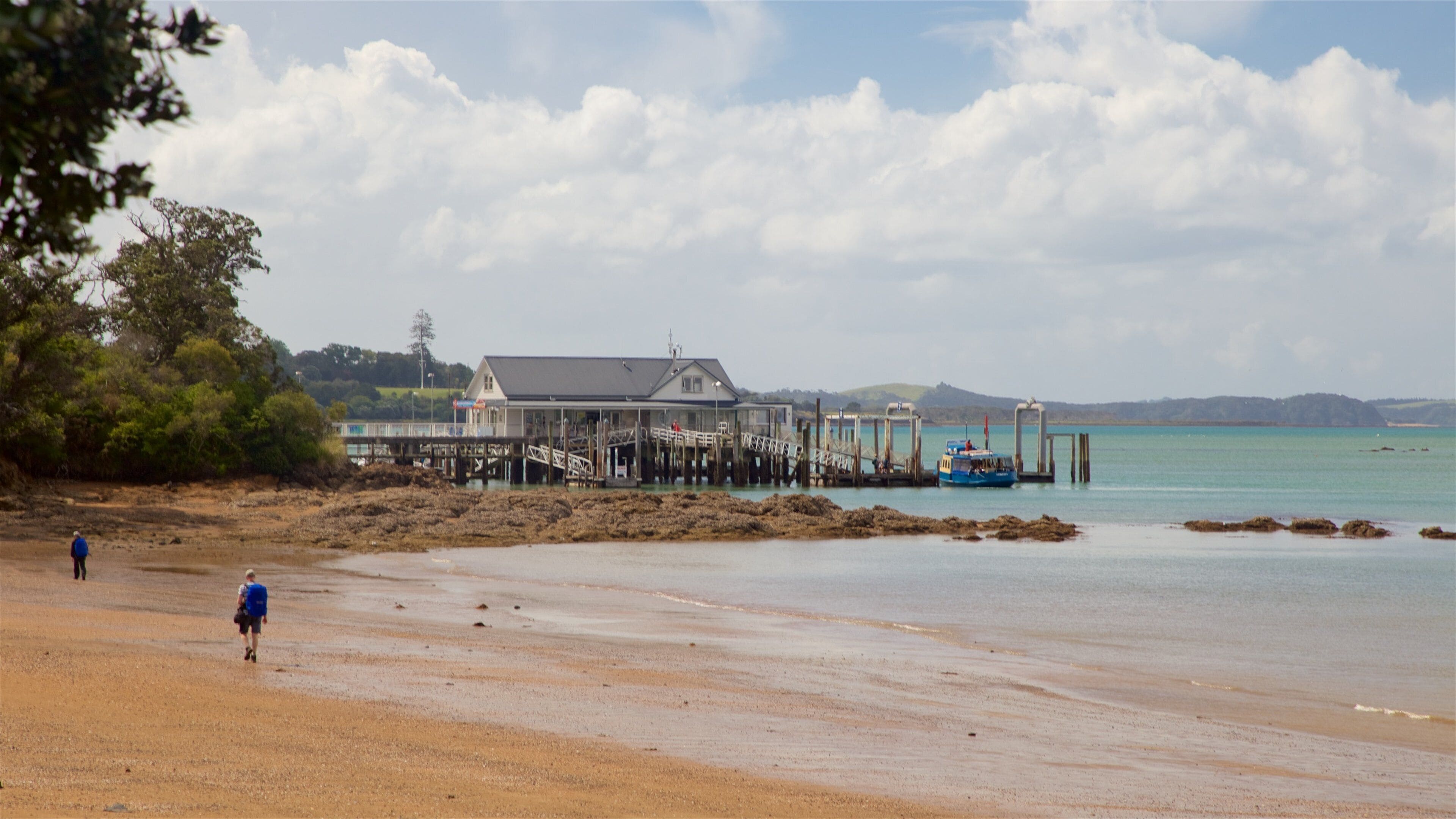 A beach with a pier and a building.