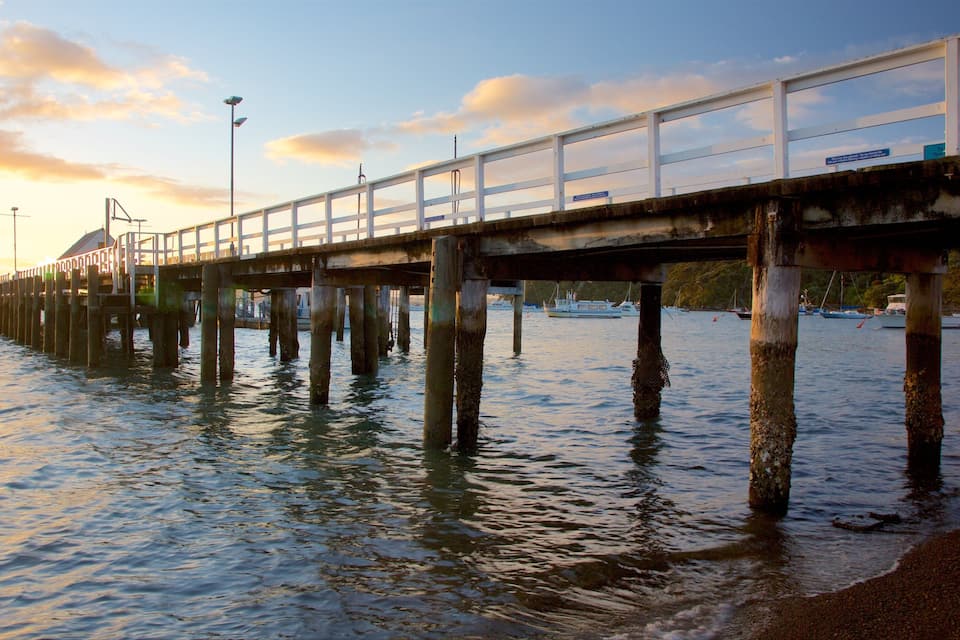 Un muelle se adentra en aguas tranquilas al atardecer.