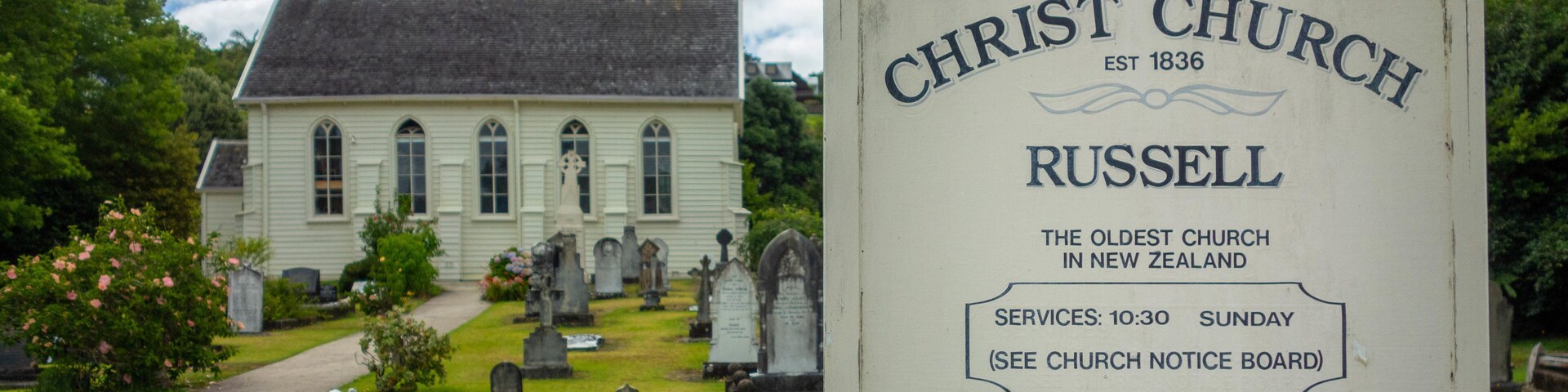 Russell Christ Church featuring signage, a cemetery and a church or cathedral