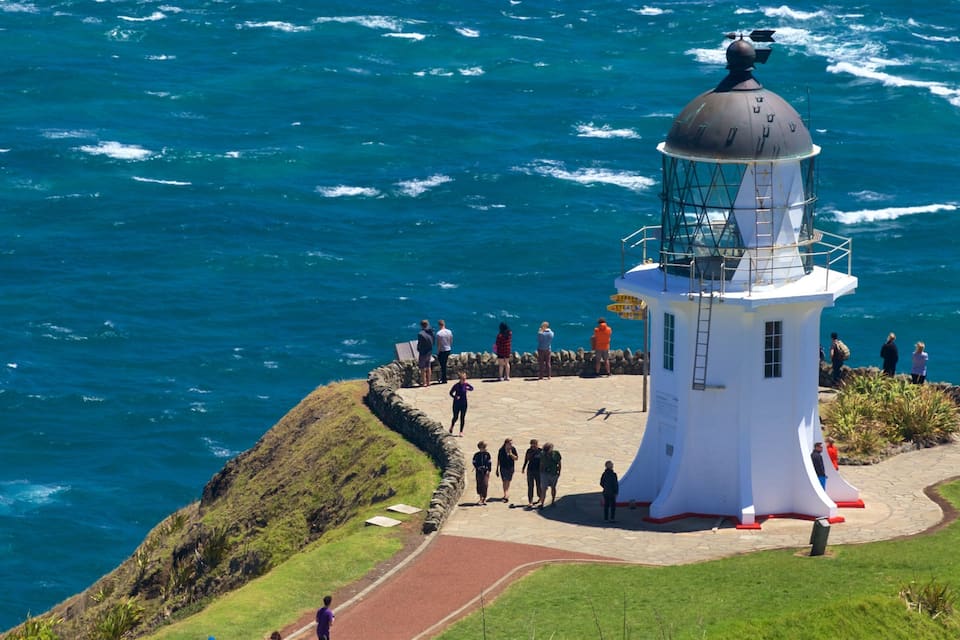 A lighthouse on a cliff overlooking the ocean.