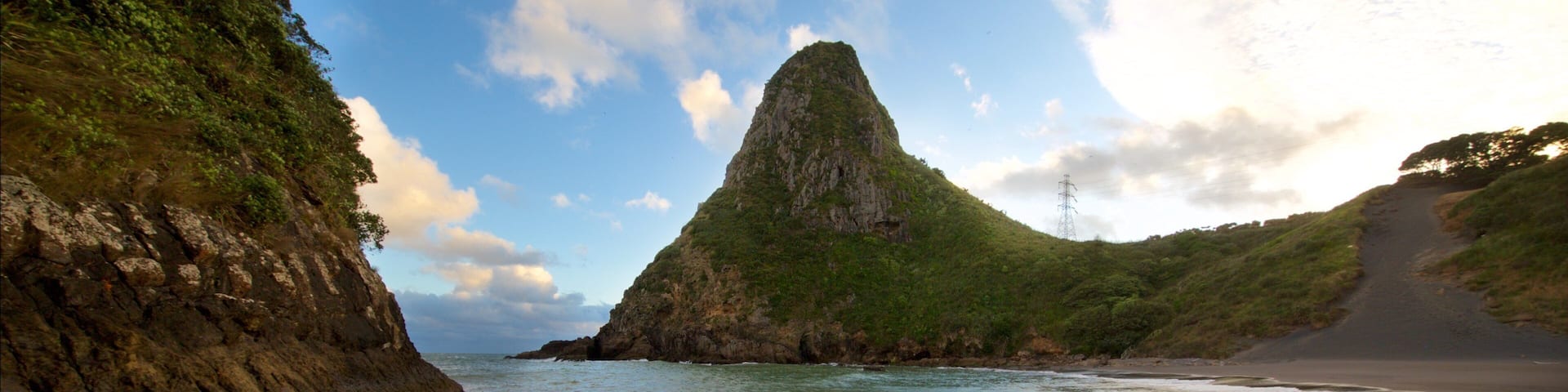 Paritutu Rock welches beinhaltet Strand, Sonnenuntergang und Bucht oder Hafen