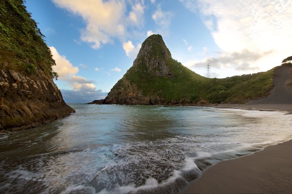 Paritutu Rock welches beinhaltet Strand, Sonnenuntergang und Bucht oder Hafen
