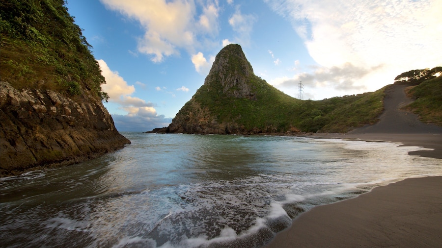 Paritutu Rock ofreciendo una playa, una bahía o un puerto y un atardecer