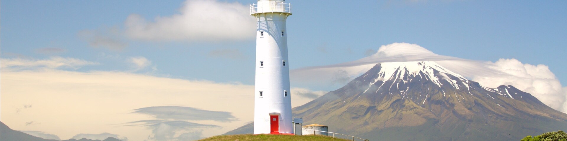 Cape Egmont Lighthouse showing a lighthouse, tranquil scenes and mountains