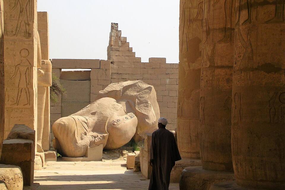 An ancient Egyptian temple with large stone statues and hieroglyphics.