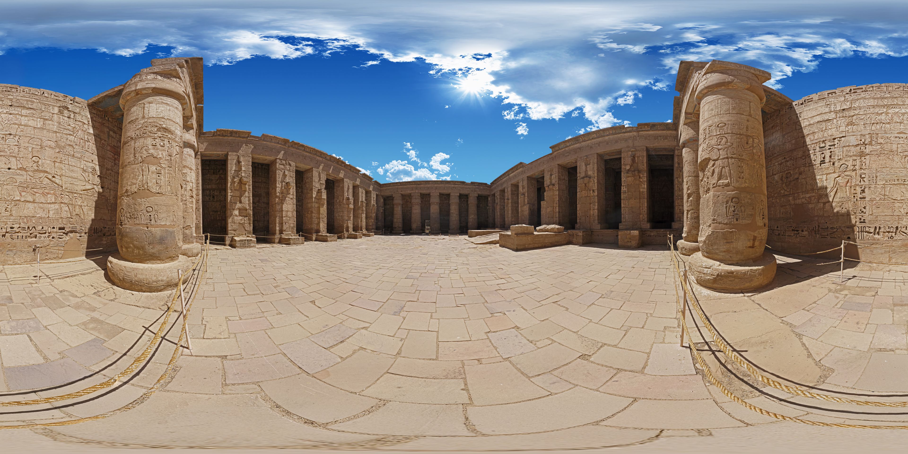 An ancient Egyptian temple with large stone columns and hieroglyphs.