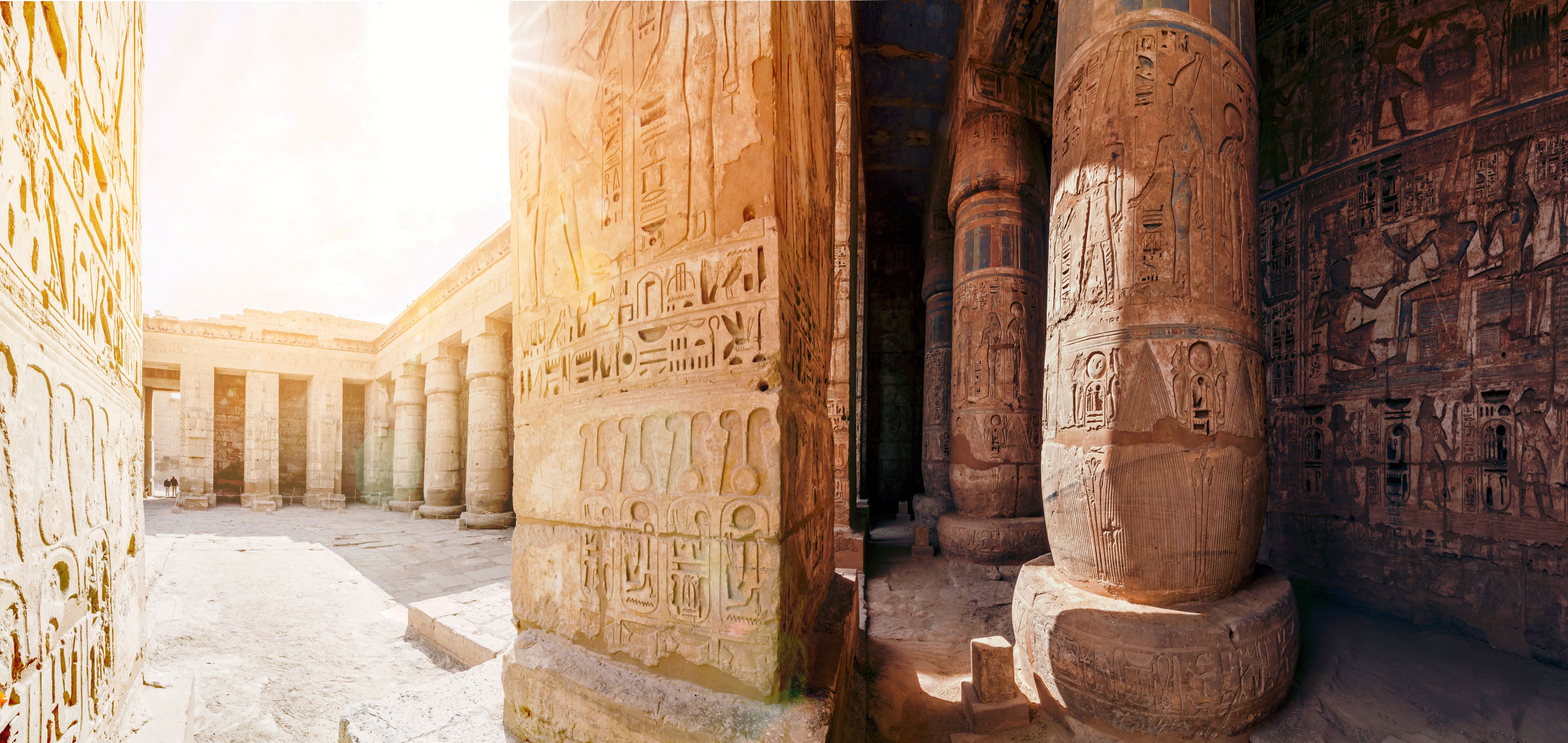 Ancient Egyptian columns with hieroglyphics, a courtyard, and a temple facade.