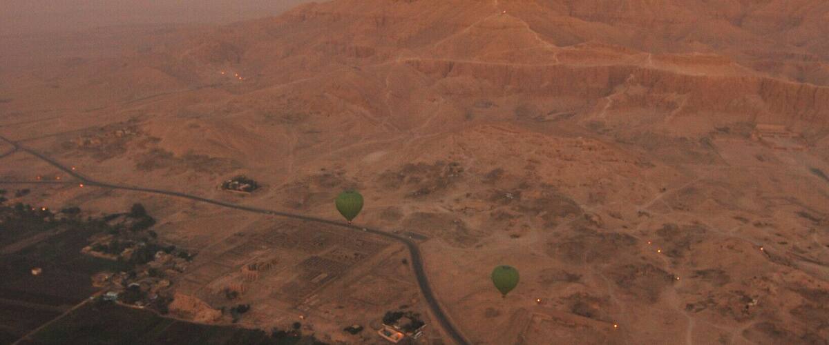 Fly above the valley of the death the curve road divide the lush green vegetation to the desert and the morning sky is paint in tinted hue of red...