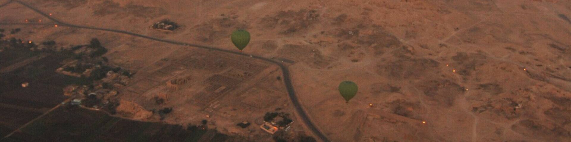 Fly above the valley of the death the curve road divide the lush green vegetation to the desert and the morning sky is paint in tinted hue of red...