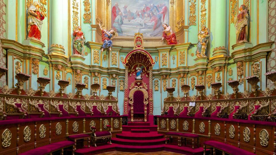 Ein prunkvolles Kircheninnere mit einem zentralen Altar, roten Samtsitzen und aufwendenden Goldverzierungen.