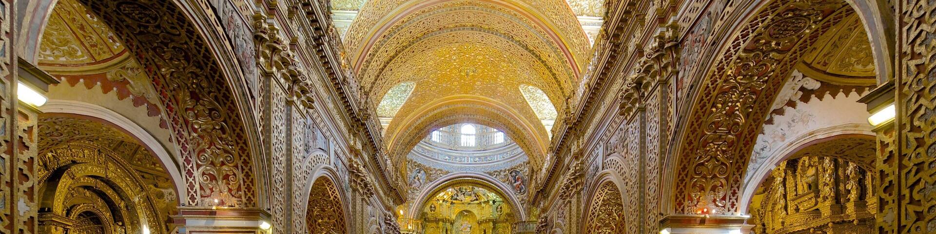 Interior de iglesia ornamentado con detalles dorados intrincados y un altar central.
