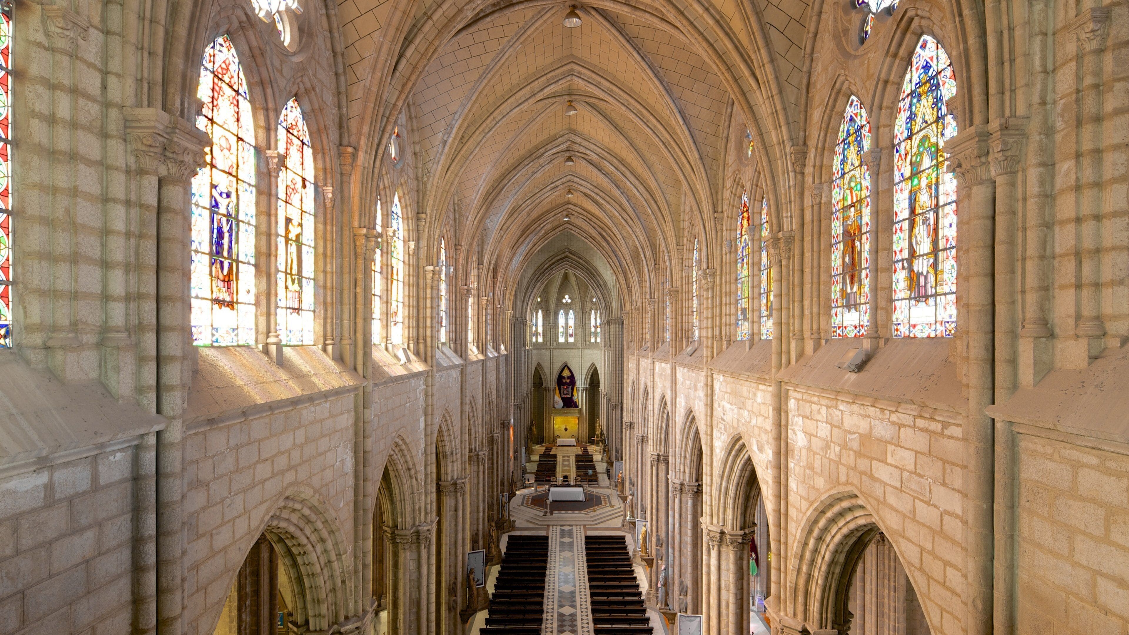A cathedral interior with arched ceilings and stained glass windows.