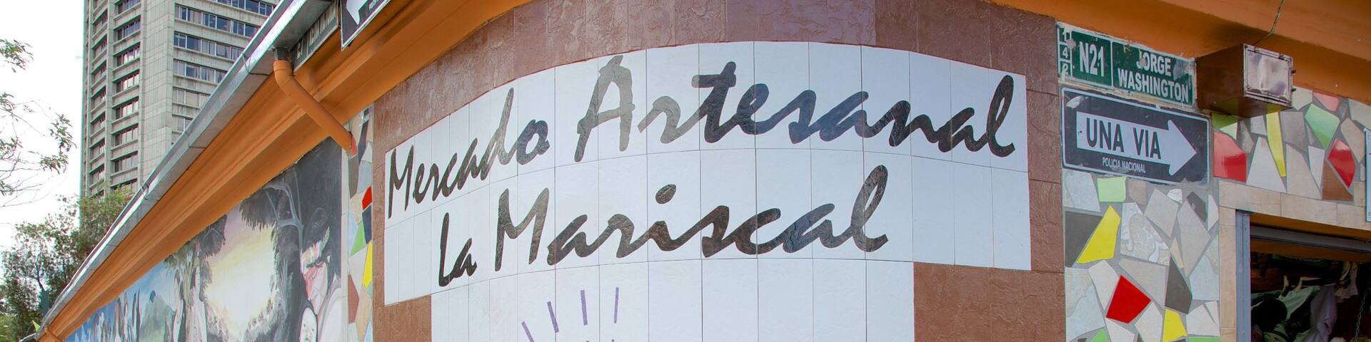 A mural on a building with the text 'Mercado Artesanal La Mariscal' and a date 'Desde 1999'.