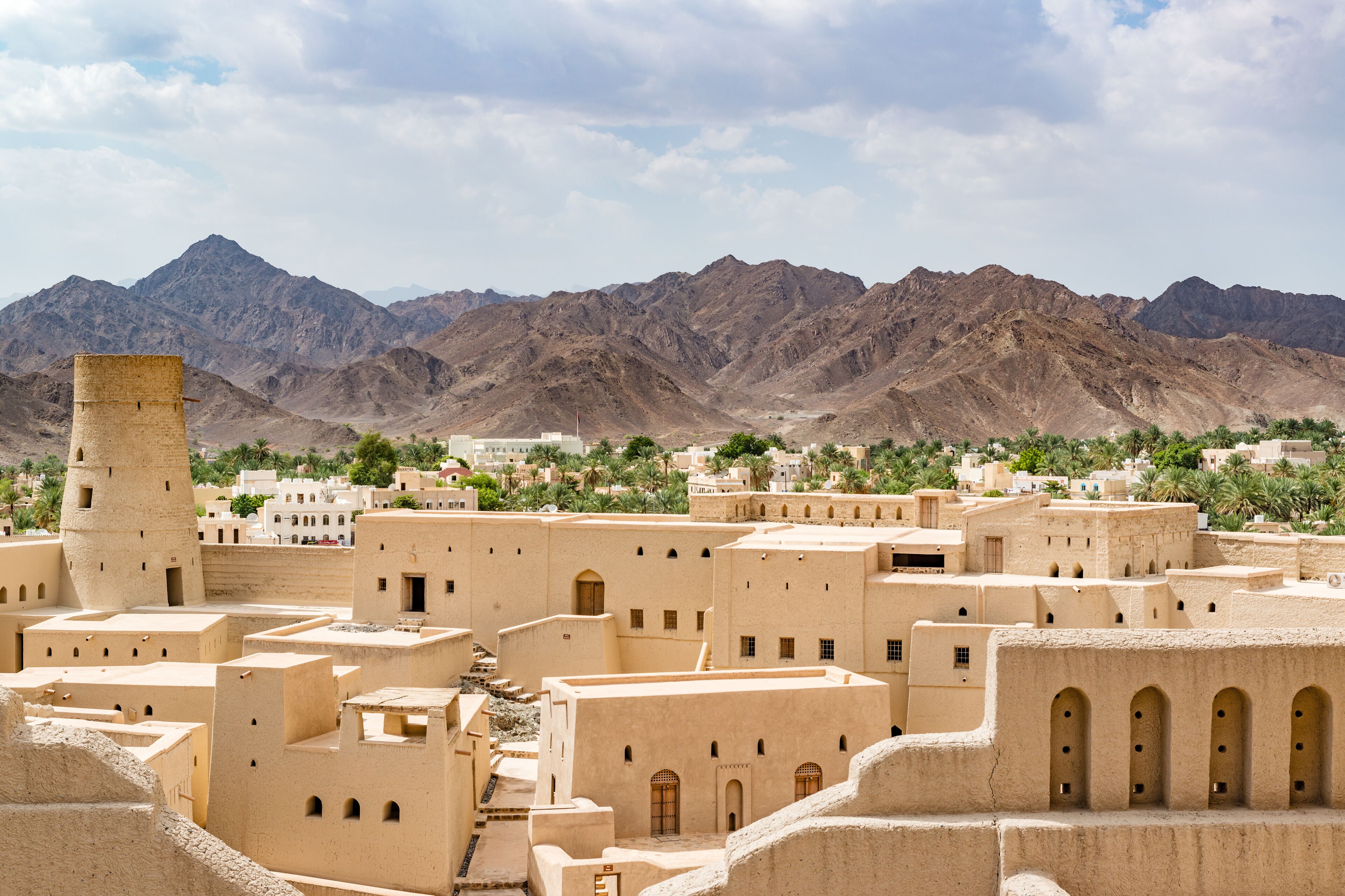 A desert town with traditional architecture, mountains in the background, and a clear sky.