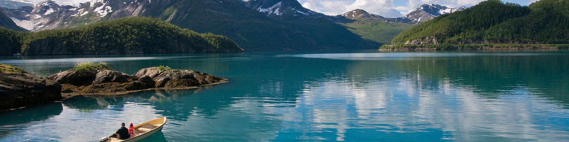 Small boat with two persons on Norwegian fjord