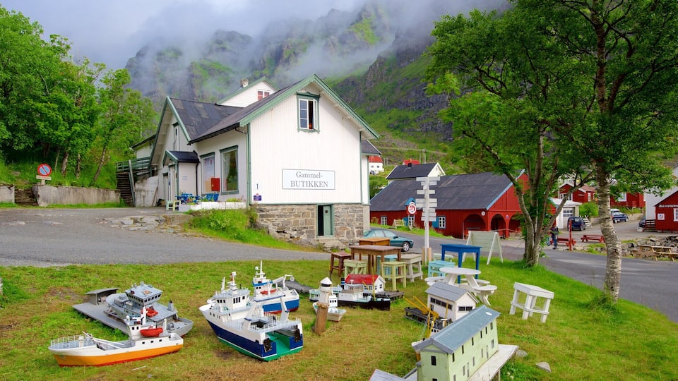 A coastal village with a white building labeled "Gammel-BUTIKKEN" surrounded by model boats and a mountainous backdrop.