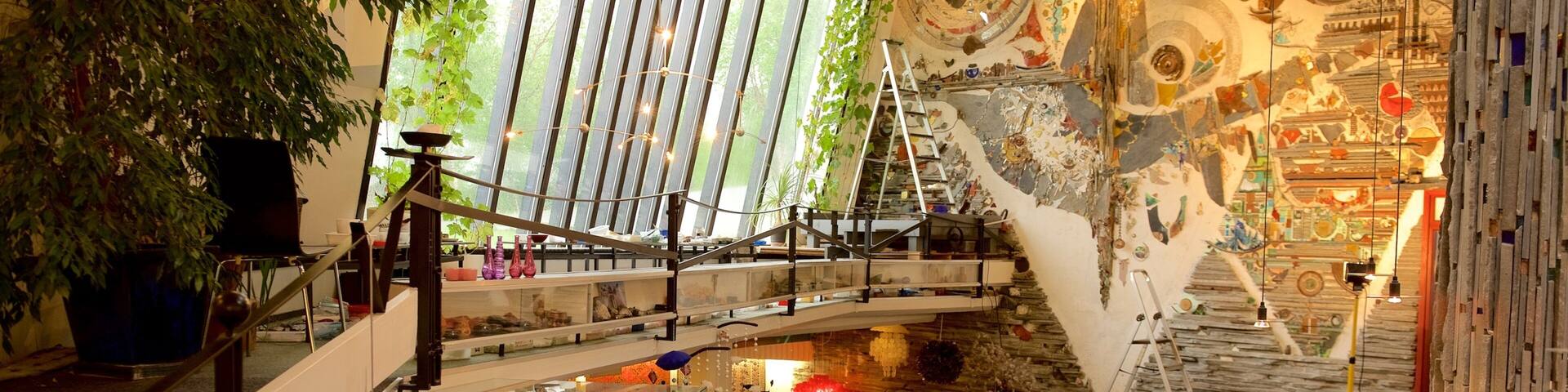 A multi-level interior space with a staircase, glass display cases, and decorative plants.