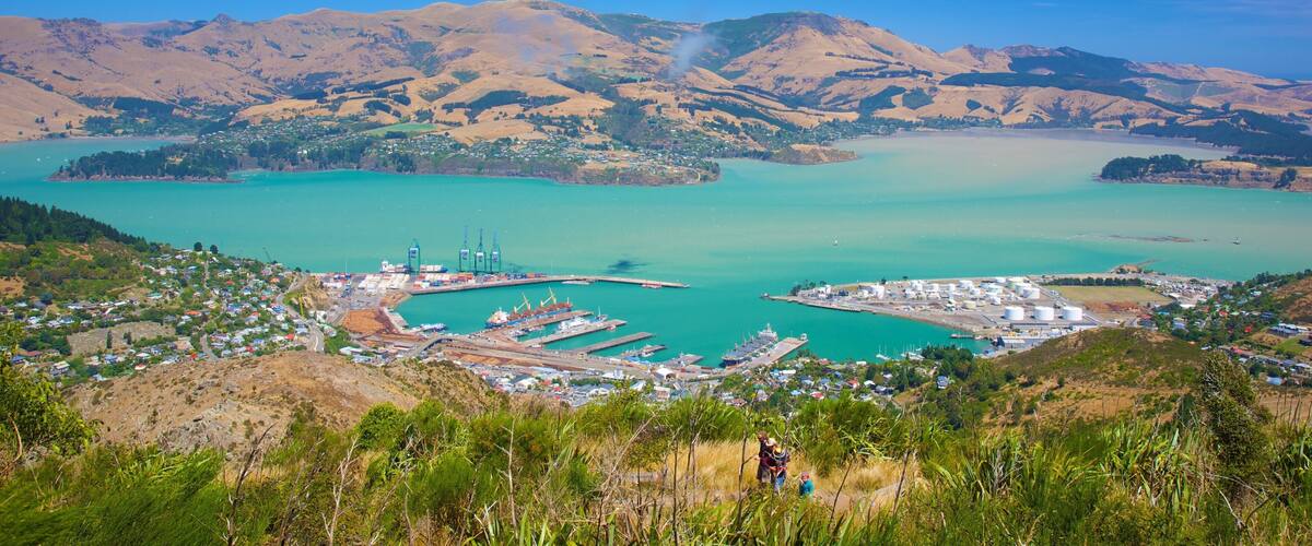 A coastal town with a harbor, mountains in the background, and a clear blue sky.