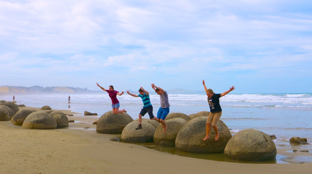 Moeraki Boulders showing rocky coastline as well as a large group of people