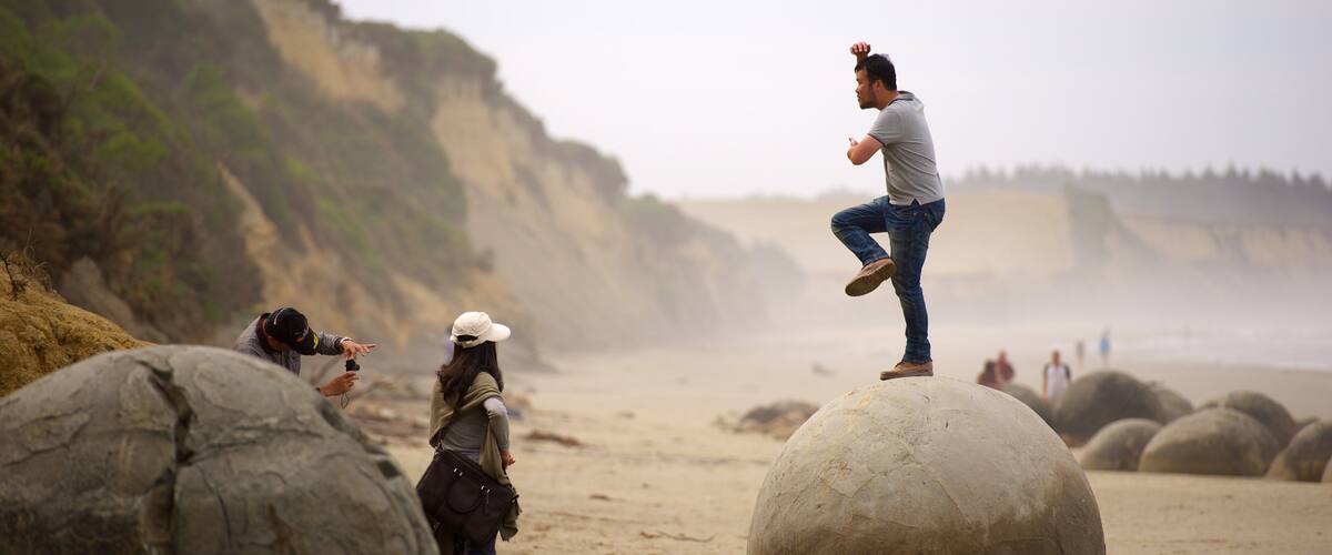 Moeraki Boulders which includes mist or fog as well as an individual male