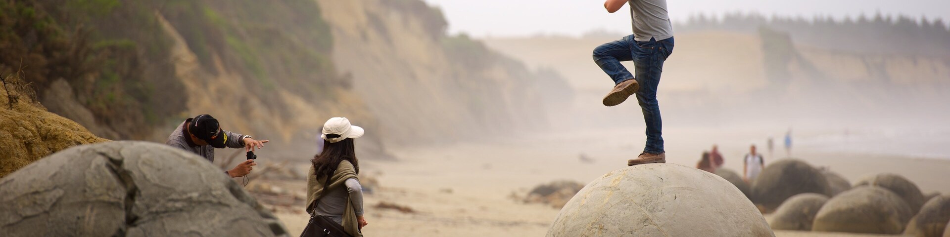 Moeraki Boulders which includes mist or fog as well as an individual male