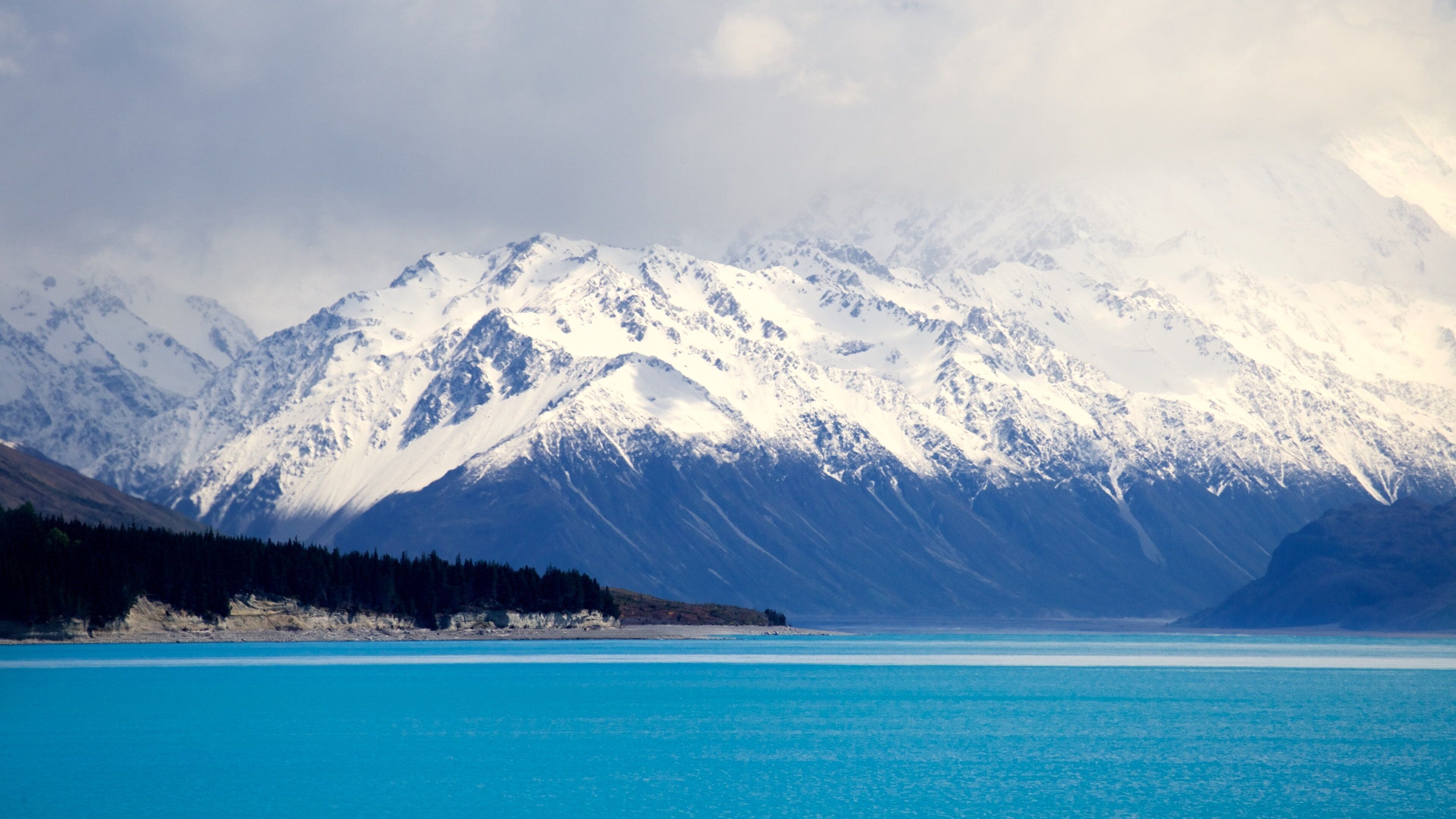 Lake Pukaki featuring a lake or waterhole, mountains and mist or fog