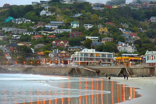 Une ville côtière avec une promenade en bois, des maisons et une plage.