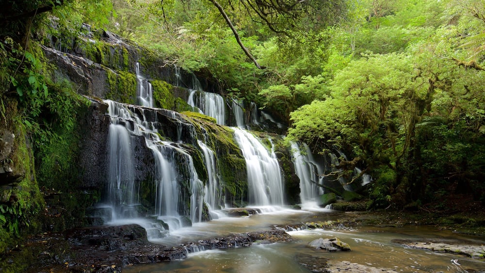 A multi-tiered waterfall surrounded by lush greenery.