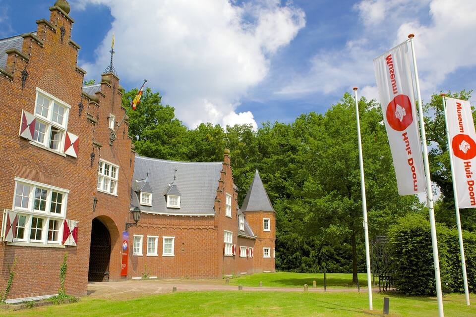 A historic brick building with a tower, flags, and banners.