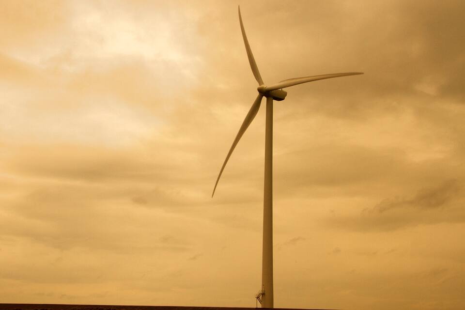 A wind turbine against a cloudy sky.
