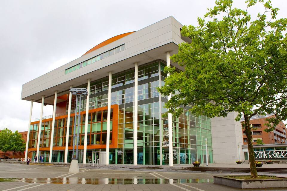 A modern building with large glass windows and an orange roof.