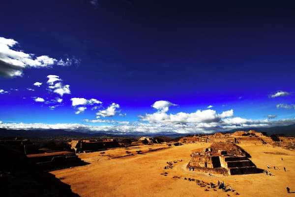 Un vaste complexe pyramidal antique comprenant de nombreuses structures et se dressant sous un ciel d’un bleu éclatant.
