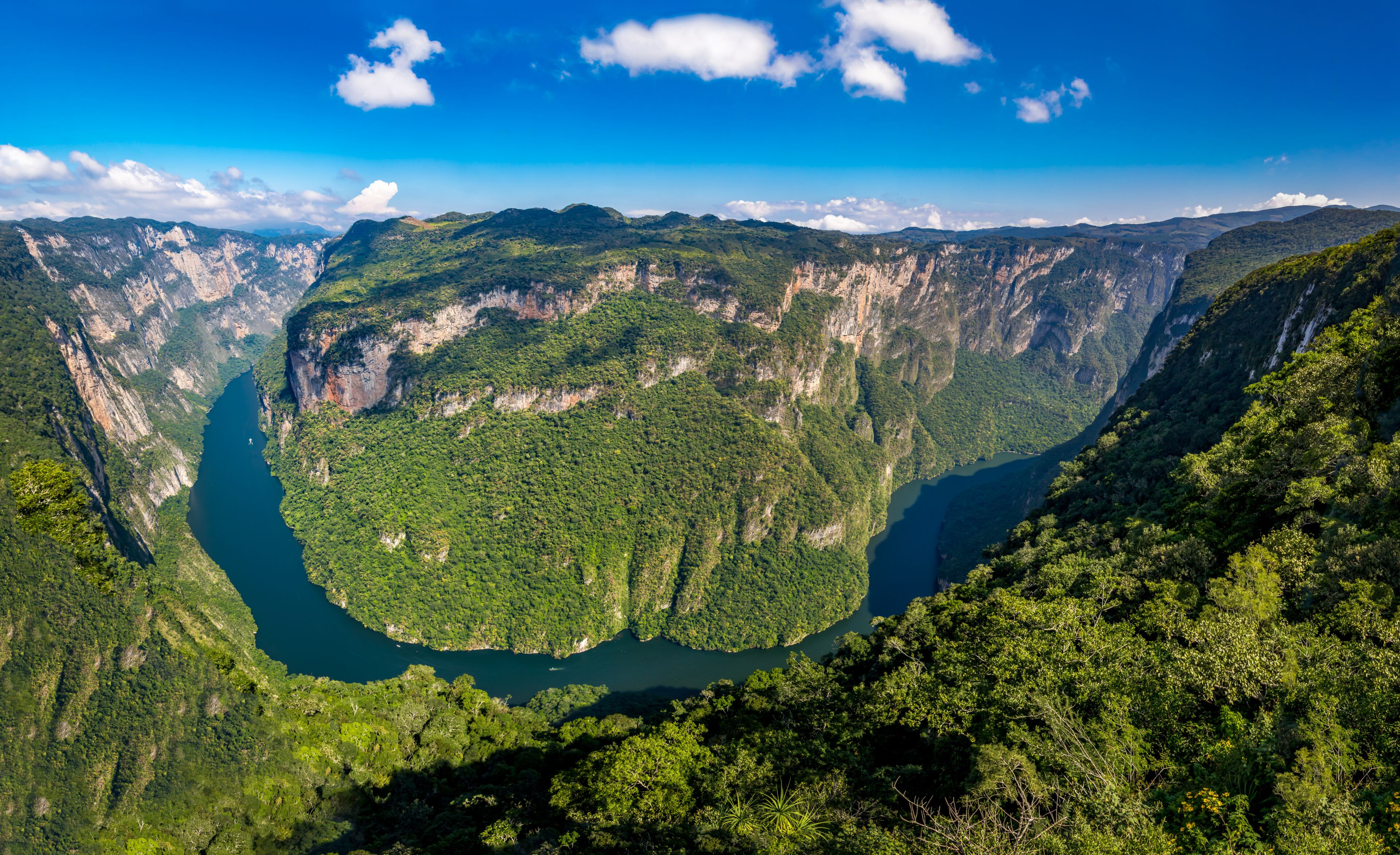 A deep canyon with steep cliffs and a river running through it.