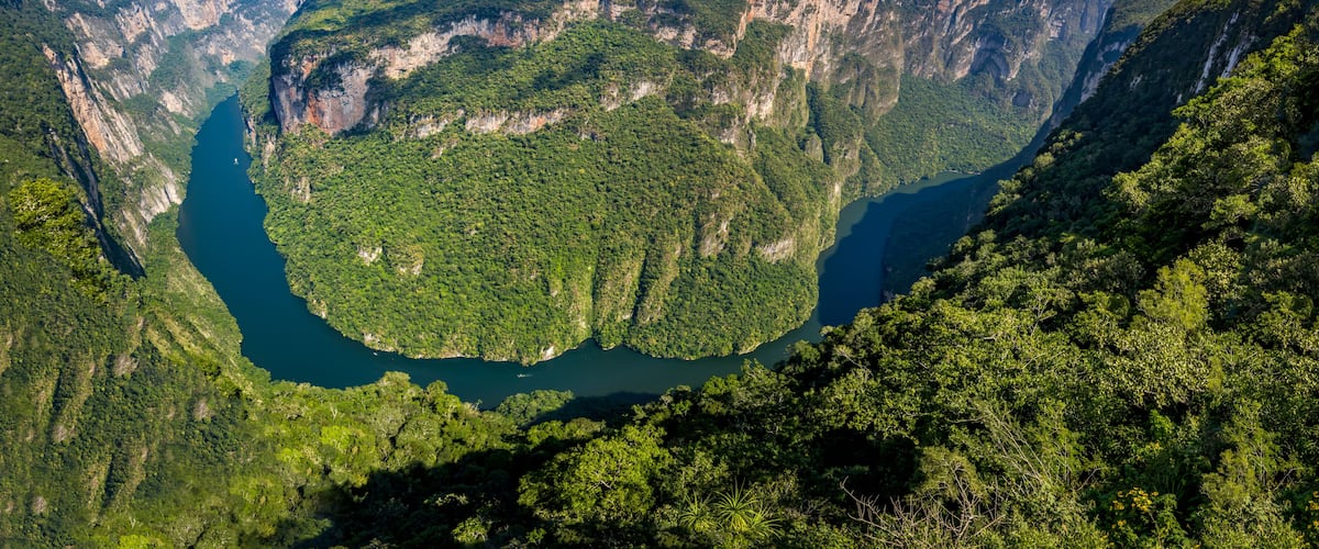 Un cañón profundo con acantilados escarpados y un río que lo atraviesa.