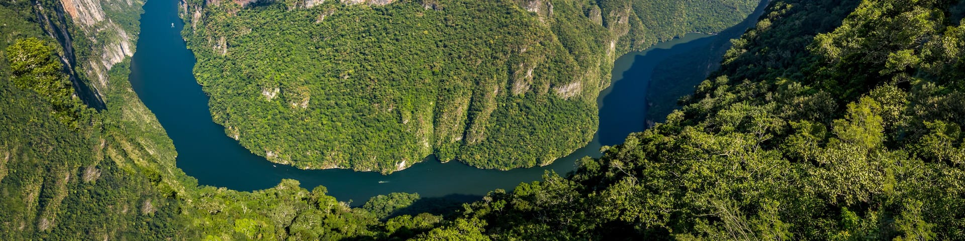 A deep canyon with steep cliffs and a river running through it.