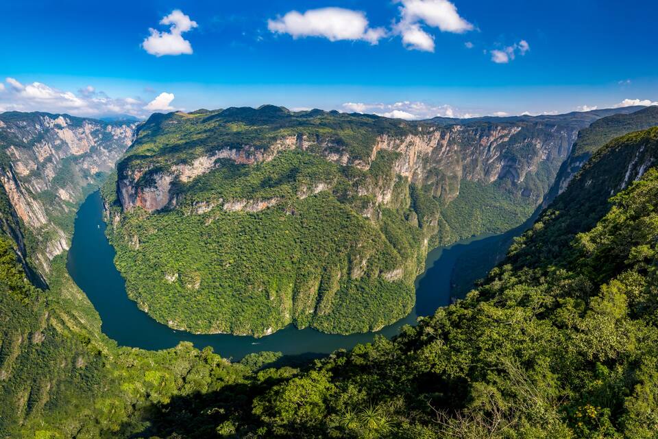 A deep canyon with steep cliffs and a river running through it.