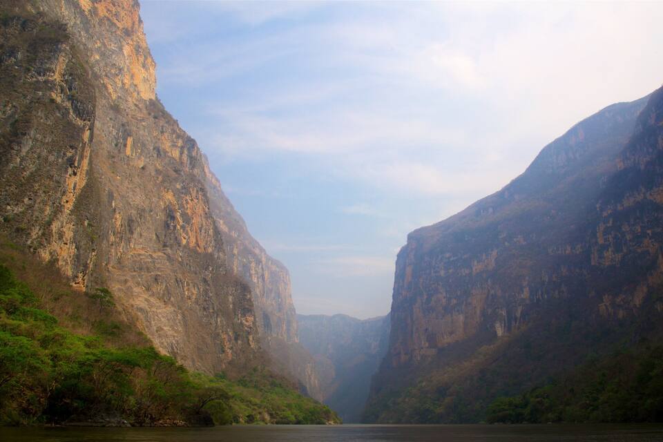 Un cañón con acantilados empinados y un río en su base.