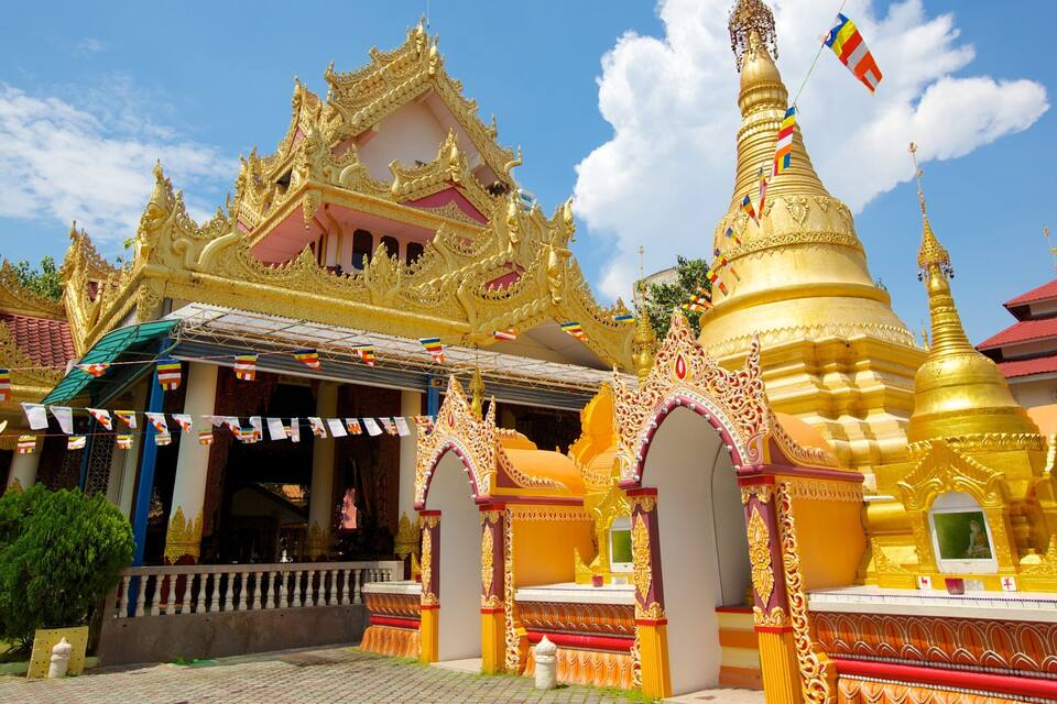 A golden temple with intricate architecture and a flag.