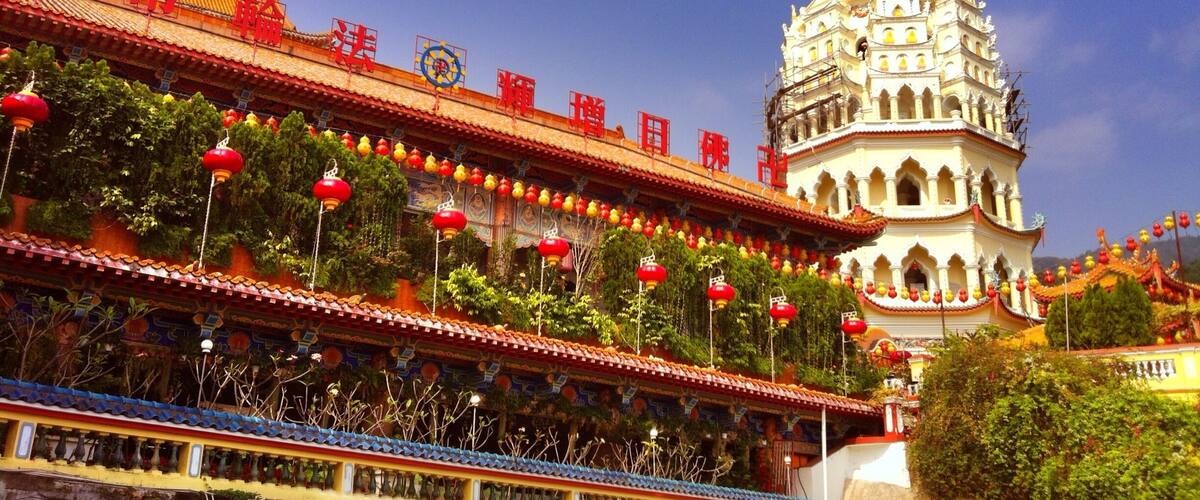A traditional temple with a golden spire, red lanterns, and intricate architecture.