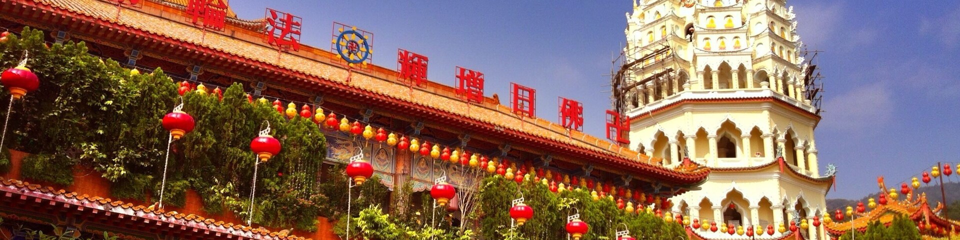 A traditional temple with a golden spire, red lanterns, and intricate architecture.