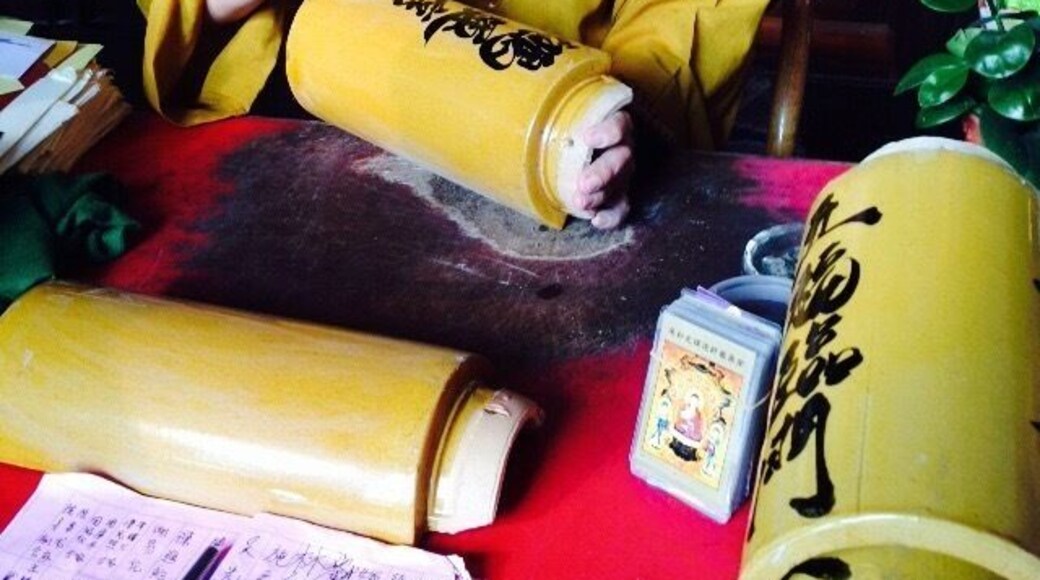A Chinese monk paints fine calligraphy on bamboo tiles at the Kek Lok Si temple
