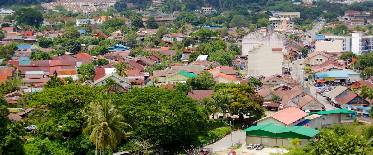 A densely populated urban area with a mix of residential and commercial buildings, surrounded by lush greenery and hills.
