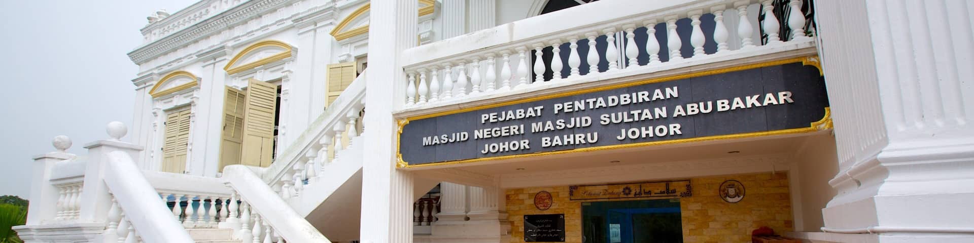 A grand building with a sign reading "PEJABAT PENITABIRAN MASJID NEGERI MASJID SULTAN ABU BAKAR JOHOR BAHRU".