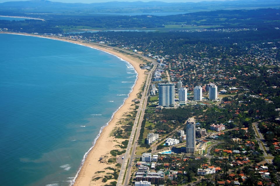 A coastal city with a beach, high-rise buildings, and dense residential areas.