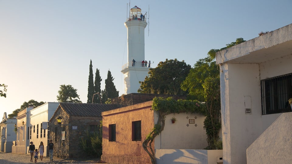 Colonia del Sacramento fyrtårn som inkluderer fyrtårn, solnedgang og historisk arkitektur