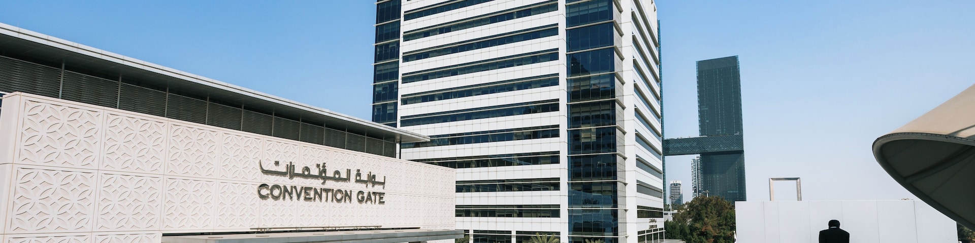 Un bâtiment moderne, sur lequel on peut lire l’inscription « ENTRÉE DU CENTRE DE CONGRÈS », et devant lequel se trouve une grande fontaine.