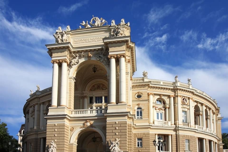 A grand neoclassical building with ornate sculptures and columns.